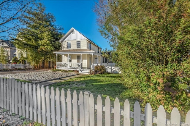 back of property with covered porch and board and batten siding