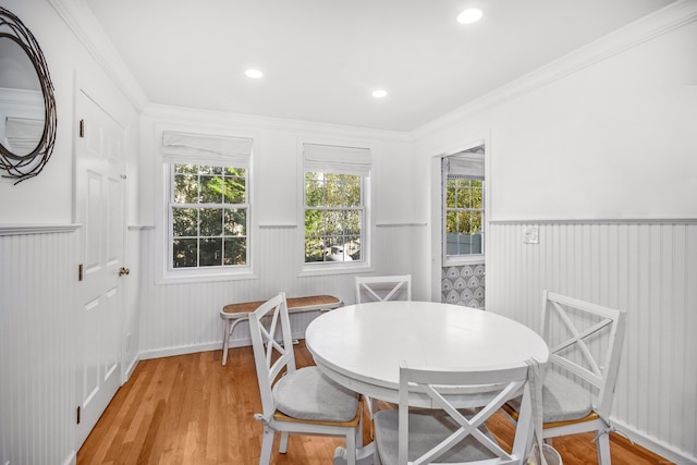 dining space with wainscoting, light wood-style floors, recessed lighting, and ornamental molding
