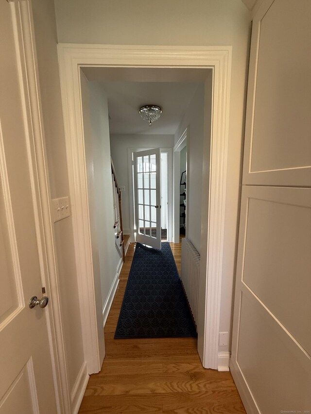 corridor with baseboards and light wood-style floors