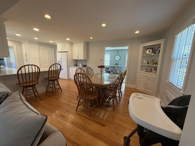 dining space featuring recessed lighting, light wood finished floors, baseboards, and built in features