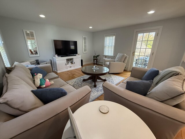 living area featuring recessed lighting, baseboards, a baseboard heating unit, and light wood-style flooring