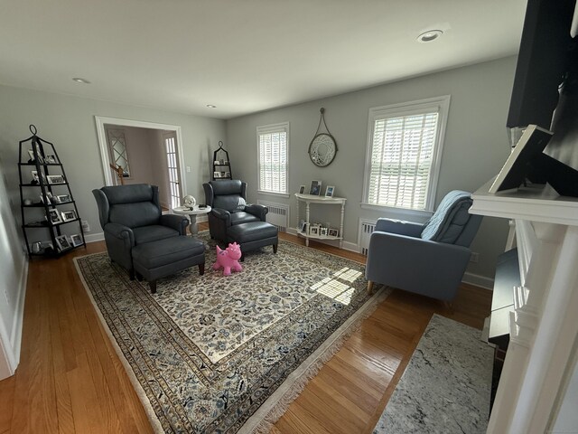 living room with radiator, baseboards, recessed lighting, and wood finished floors