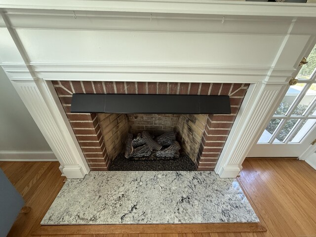 room details featuring baseboards, a fireplace, and wood finished floors
