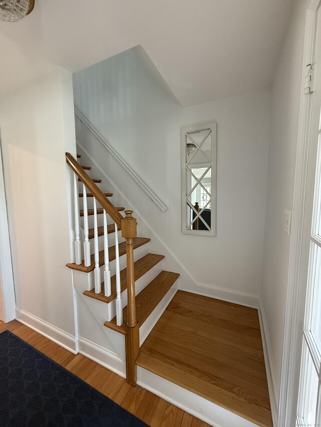 staircase featuring baseboards and wood finished floors
