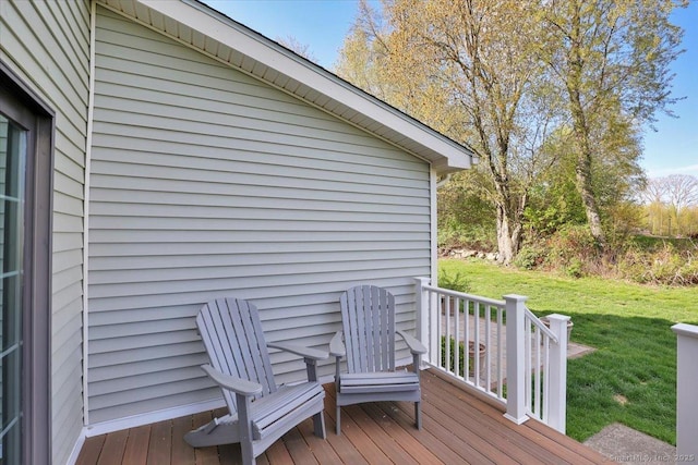 wooden deck featuring a lawn