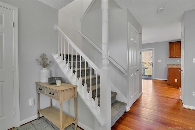 staircase with baseboards and wood finished floors