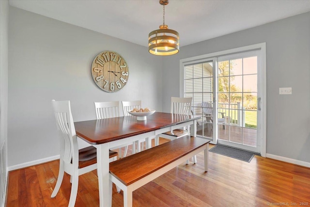 dining room featuring baseboards, wood finished floors, and a chandelier