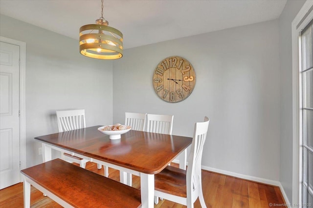 dining room featuring baseboards, a notable chandelier, and wood finished floors