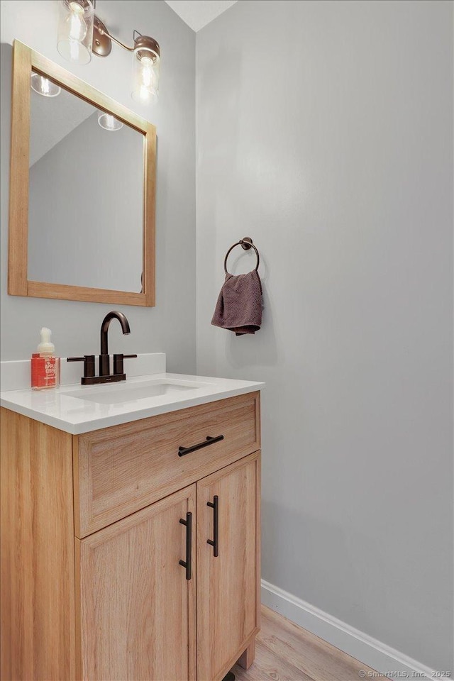 bathroom featuring baseboards, vanity, and wood finished floors