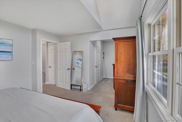 bedroom with baseboards and light carpet