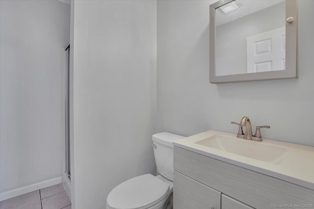 bathroom with tile patterned floors, a shower with shower door, vanity, and toilet