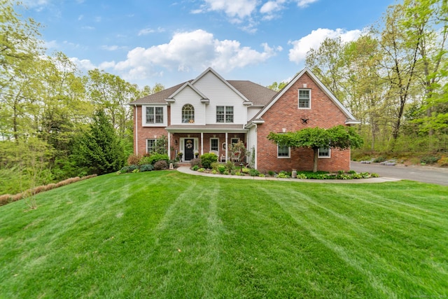 45 N Gate Rd, Woodbury, CT 06798 - view of front facade with brick siding, a porch, and a front yard