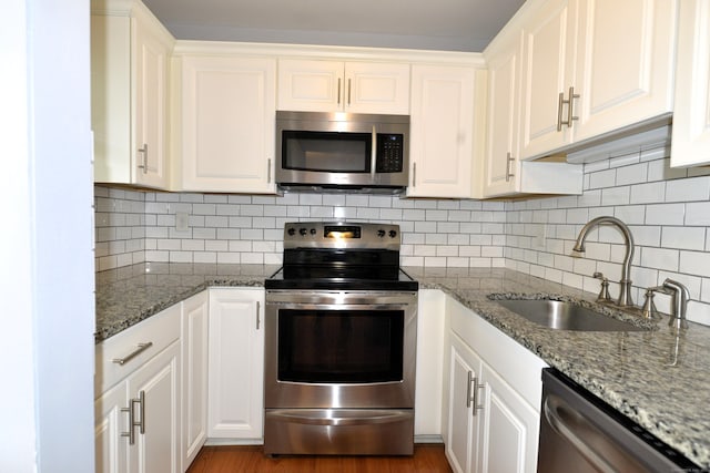 107 Hidden Knolls Cir Unit 107, Monroe, CT 06468 - kitchen featuring appliances with stainless steel finishes, a sink, white cabinets, and decorative backsplash