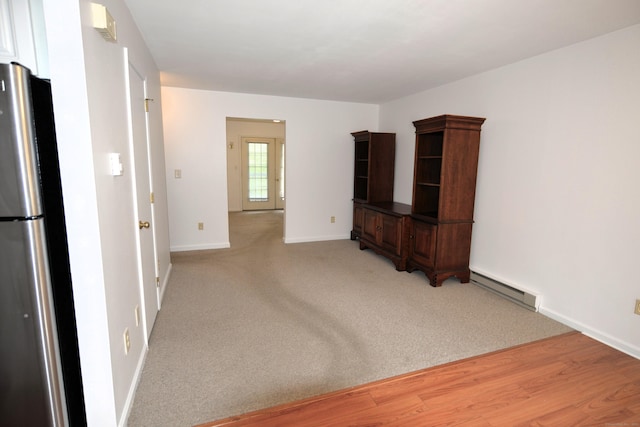 107 Hidden Knolls Cir Unit 107, Monroe, CT 06468 - unfurnished living room featuring baseboard heating, baseboards, and light wood-style floors