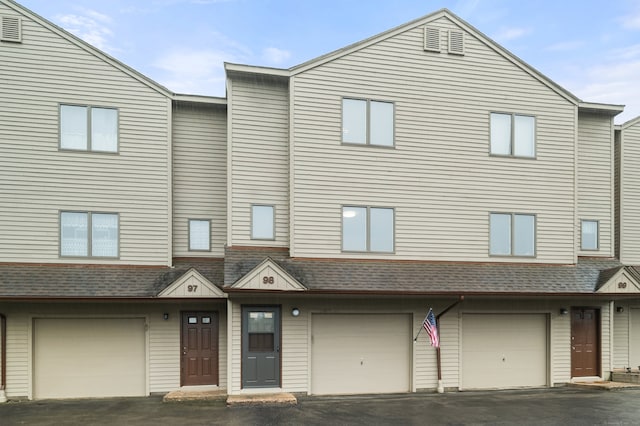 489 Wolcott St Apt 98, Bristol, CT 06010 - view of property with an attached garage, driveway, and roof with shingles