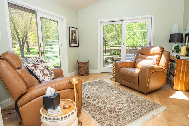 living room with baseboards, vaulted ceiling, a healthy amount of sunlight, and wood finished floors