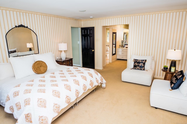carpeted bedroom featuring wallpapered walls and ensuite bath