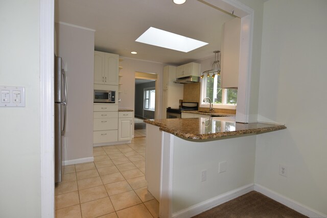 59 Old Ridgebury Rd, Danbury, CT 06810 - kitchen featuring under cabinet range hood, a sink, a peninsula, appliances with stainless steel finishes, and a skylight