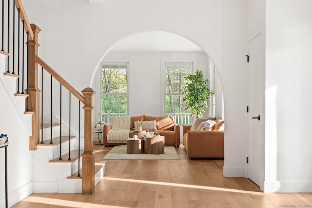 82 Indian Hill Rd, Wilton, CT 06897 - living room with wood finished floors, arched walkways, and stairway