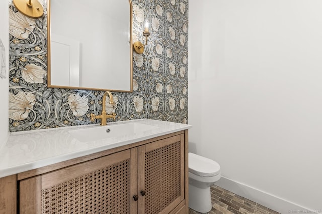82 Indian Hill Rd, Wilton, CT 06897 - bathroom featuring vanity, toilet, wallpapered walls, and baseboards