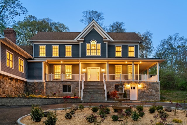 82 Indian Hill Rd, Wilton, CT 06897 - view of front of home featuring stone siding, covered porch, and stairway