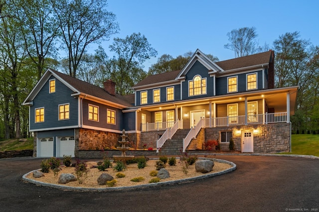 82 Indian Hill Rd, Wilton, CT 06897 - view of front facade with stone siding, driveway, stairway, an attached garage, and a porch