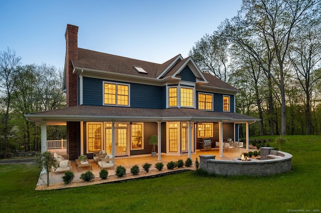 82 Indian Hill Rd, Wilton, CT 06897 - back of house with a chimney, a yard, roof with shingles, covered porch, and a fire pit
