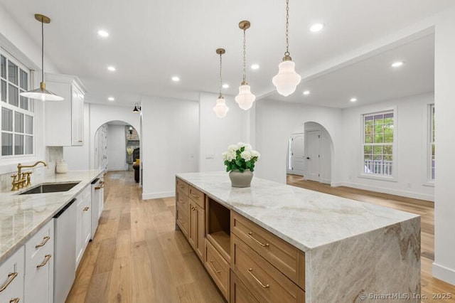 82 Indian Hill Rd, Wilton, CT 06897 - kitchen featuring arched walkways, a sink, light wood-style flooring, recessed lighting, and white cabinetry