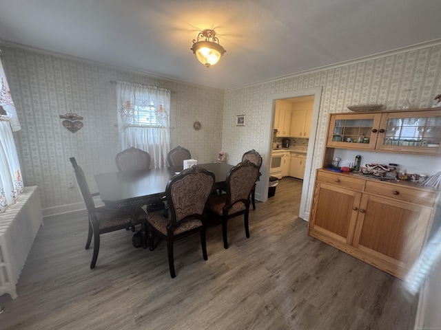 34 Knollwood Rd, East Hartford, CT 06118 - dining space with light wood-style floors, wallpapered walls, and ornamental molding