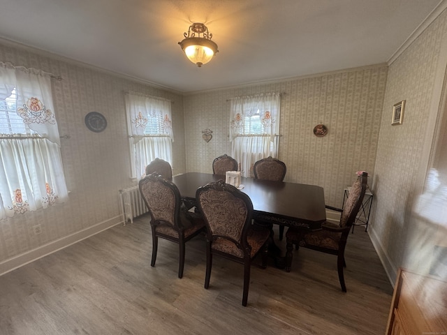 34 Knollwood Rd, East Hartford, CT 06118 - dining space featuring wallpapered walls, wood finished floors, ornamental molding, and radiator heating unit