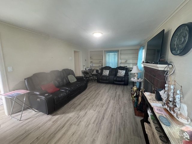 34 Knollwood Rd, East Hartford, CT 06118 - living room featuring wood finished floors, a fireplace, built in features, and crown molding