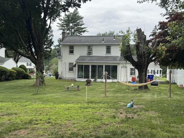34 Knollwood Rd, East Hartford, CT 06118 - rear view of property with a sunroom, a yard, a chimney, and an outdoor fire pit