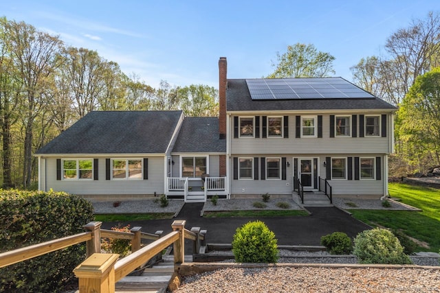 95 Pepperidge Cir, Stratford, CT 06614 - view of front of home with a shingled roof, a chimney, and roof mounted solar panels