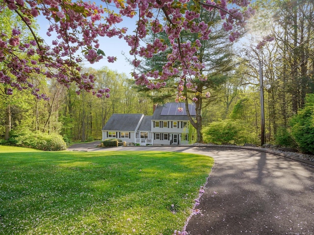 95 Pepperidge Cir, Stratford, CT 06614 - view of front facade with a porch, a wooded view, and a front lawn