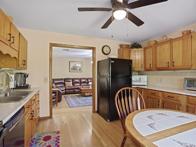 95 Pepperidge Cir, Stratford, CT 06614 - kitchen with a sink, freestanding refrigerator, white microwave, dishwashing machine, and light wood-style flooring