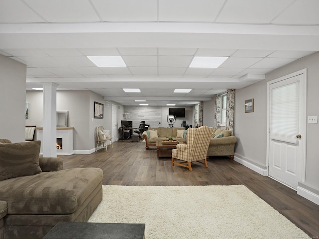 95 Pepperidge Cir, Stratford, CT 06614 - living room featuring dark wood-style flooring, baseboards, a lit fireplace, and a drop ceiling