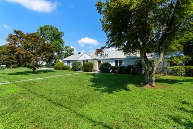 single story home with a chimney and a front lawn