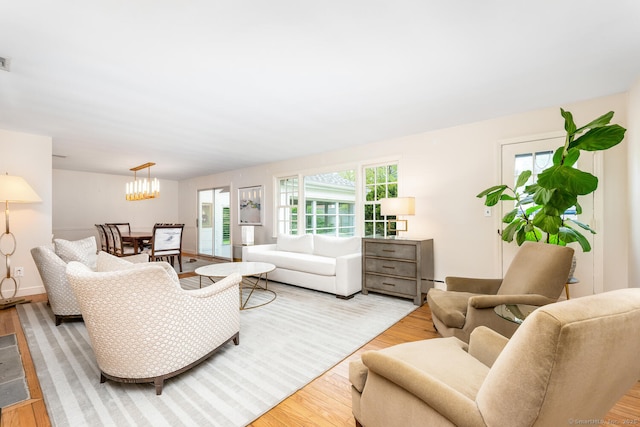 living room featuring visible vents, wood finished floors, and a notable chandelier