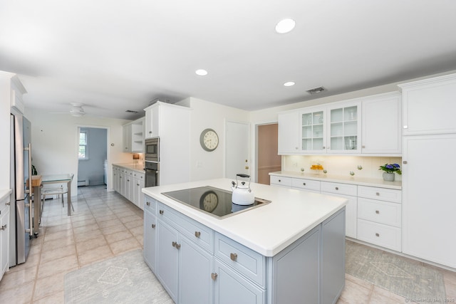 kitchen with visible vents, a center island, light countertops, stainless steel appliances, and white cabinetry