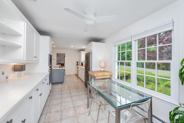 kitchen with light countertops, white cabinetry, a ceiling fan, and stainless steel appliances