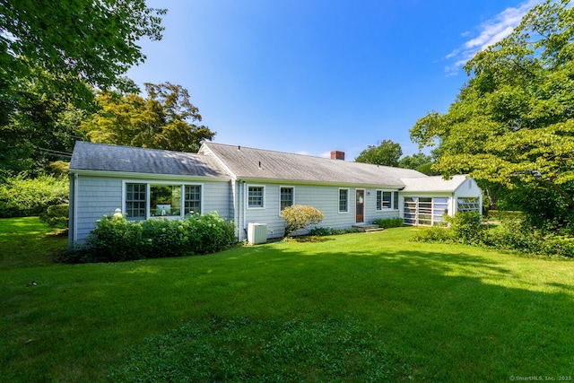 single story home featuring a chimney and a front yard