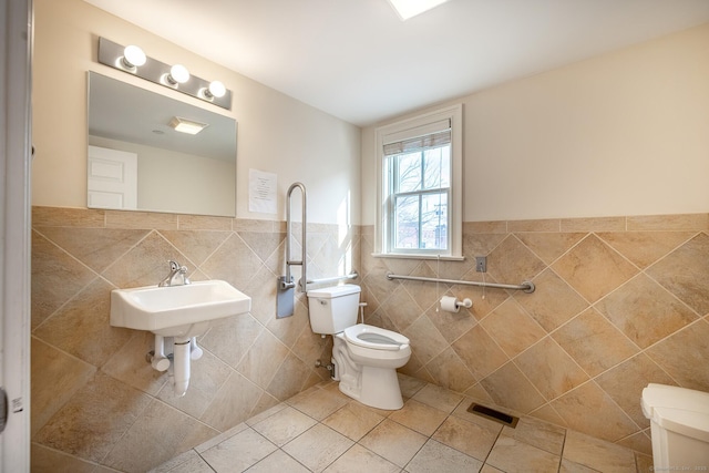27 Catoonah St, Ridgefield, CT 06877 - bathroom with tile patterned flooring, visible vents, wainscoting, toilet, and tile walls