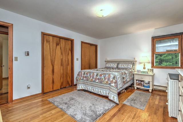 478 Alpom Dr, Orange, CT 06477 - bedroom featuring a baseboard heating unit, multiple closets, and wood finished floors