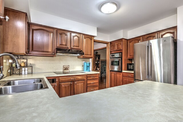 478 Alpom Dr, Orange, CT 06477 - kitchen with appliances with stainless steel finishes, a sink, under cabinet range hood, light countertops, and decorative backsplash