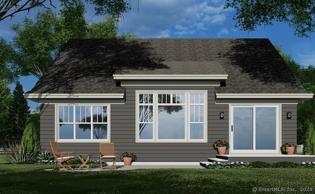 back of property with a lawn and a shingled roof