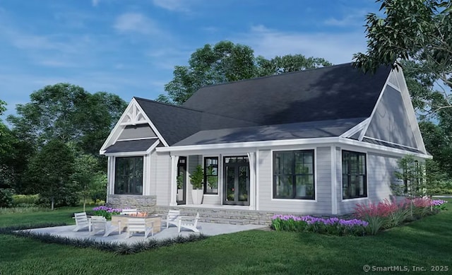 rear view of property with a lawn and a patio