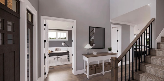 entryway featuring stairs, a high ceiling, baseboards, and wood finished floors