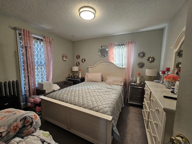 bedroom featuring radiator, dark carpet, and a textured ceiling