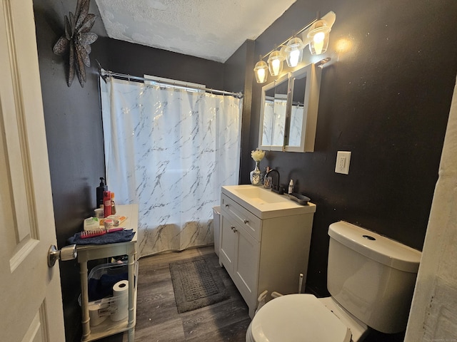 full bathroom featuring shower / tub combo with curtain, vanity, toilet, a textured ceiling, and wood finished floors