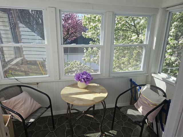 sunroom featuring wood walls